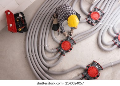 Modern Residential Heat Recuperation System Pipelines Installed by Professional Caucasian HVAC Technician in His 40s. Heat Ventilation Recovery Technology.