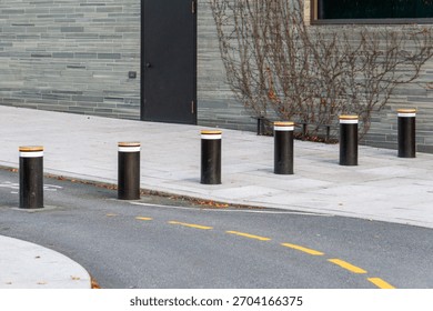 Modern Retractable Security Bollards on Urban Sidewalk at Building Entrance