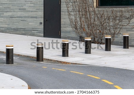 Modern Retractable Security Bollards on Urban Sidewalk at Building Entrance
