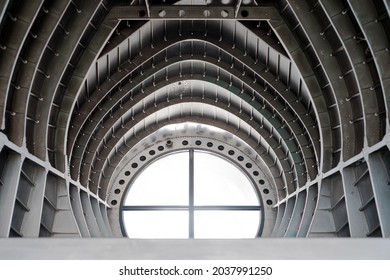 modern retro ceiling metal steel arch wall with round window light, part inside old airplane. abstract background 