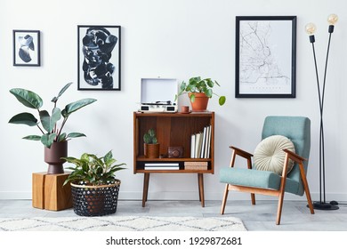Modern retro composition of living room interior with design wooden cabinet, stylish armchair, mock up poster map, plants, vinyl recorder, books and personal accessories in home decor. Template. - Shutterstock ID 1929872681