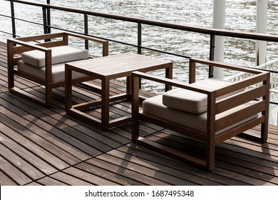 Modern Riverside Cafe With Wooden Sofa And Furniture.