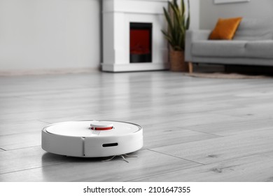 Modern Robot Vacuum Cleaner On Wooden Floor In Room