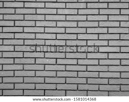 Modern rock stone wall background made of bricks on a wall of the building with rough texture and interesting antique retro natural pattern in black and white
