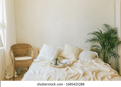 Modern Romantic Scandi Boho Style Bedroom Interior With Decorative Pillows, Green Plant And Empty Wall For Poster Or Art Mock-ups. Light Warm Cozy Comfortable Home. Slow Living Concept.