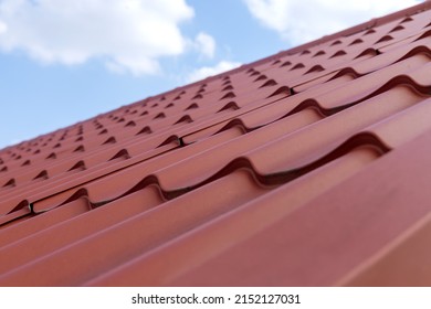 Modern roof made of corrugated red metal tiles roofing