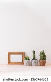 Modern room decoration. Various cactus and succulent plants in different pots. Mock-up with a wooden frame. - Shutterstock ID 1363764653