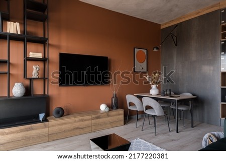 Modern room with tv and dining table, stylish furniture and trendy orange wall