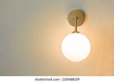 Modern round wall lamp light bulbs ball shape have a gold metallic centerpiece on wall decoration home and living with space for copy text. Concept contemporary building