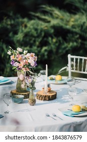 Modern Rustic Table Setting For A Garden Party. Outdoor Wedding Reception Decor, Anniversary Celebration Or Elegant Baptism Dining. Colorful And Romantic Dinner Set Up With Flowers And Candles.