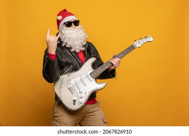 Modern Santa Claus rock n roller play guitar emotionally isolated on yellow background - Powered by Shutterstock