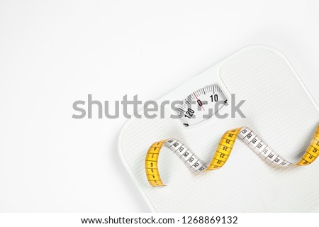 Modern scales and tape measure isolated on white, top view