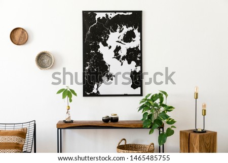 Modern scandinavian interior of living room with wooden console, avocado plant, armchair, lamp, basket and black elegant personal accessories. Stylish mock up poster map. Design home decor. Template. 
