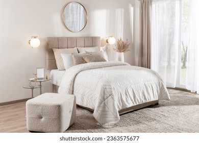 Modern Scandinavian-Style Bedroom with Neutral Tones, Featuring a Double Bed with White Cover, Rectangular Pouf, and Mirror, Bathed in Neutral Daylight from a Window - Powered by Shutterstock