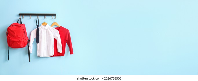 Modern school uniform and backpack hanging on color wall - Shutterstock ID 2026758506