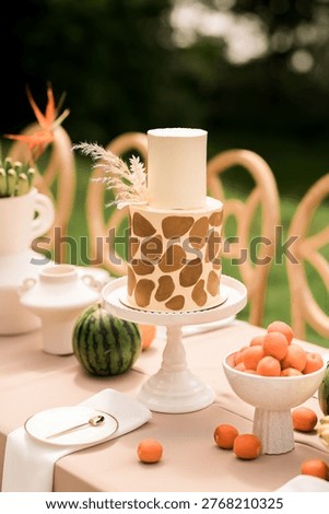 Modern sculptural cake with giraffe pattern design, minimalist luxury dessert centerpiece, elegant outdoor celebration styling with warm natural light and refined aesthetic