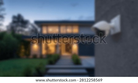 A modern security camera is mounted on the exterior wall of a contemporary house at dusk, providing surveillance and safety.