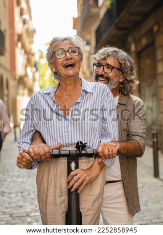 Modern senior couple with electric scooter
