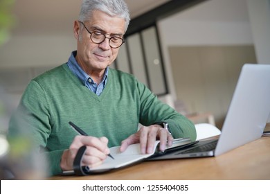  Modern senior man working on laptop at home                               - Powered by Shutterstock