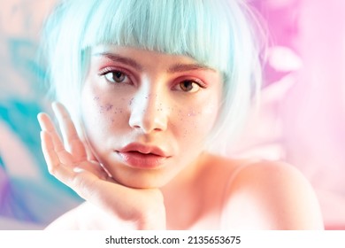 Modern sensual  blond european woman with short hair, perfect skin, contemporary makeup and glitter on face. Girl opened plump lips looking at camera. Ad for youth and teen skincare cosmetics