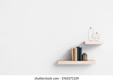 Modern shelves with books and decor on white wall