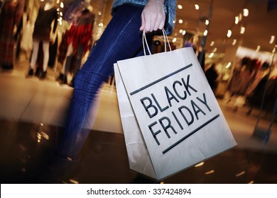 Modern shopper with Black Friday paperbag going in the mall - Shutterstock ID 337424894