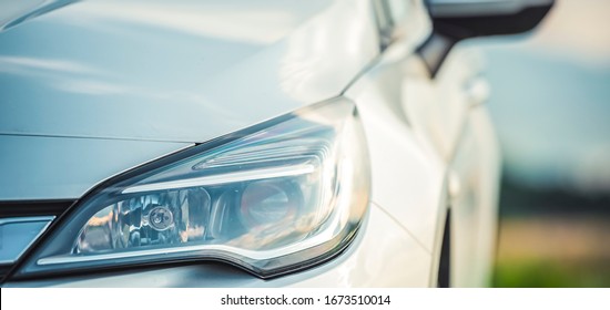 Modern Silver Car Parking On The Road. Close Up. Headlights Detail.