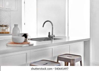 Modern silver taps with a sink on a counter top with plastic benches and the sunlight came through the doors, very clean area.