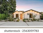 Modern single-story house with a minimalist garden at sunset, featuring clean lines and warm lighting.