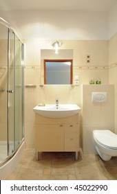 A Modern Sink On The Wooden Cupboard In A Tiled Bathroom Underneath A Mirror.