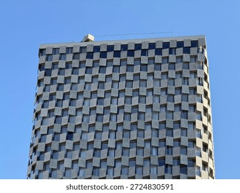 Modern Skyscraper Facade with Checkerboard Pattern Against Blue Sky