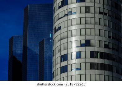 Modern skyscrapers and tiled cylindrical building against blue sky - Powered by Shutterstock