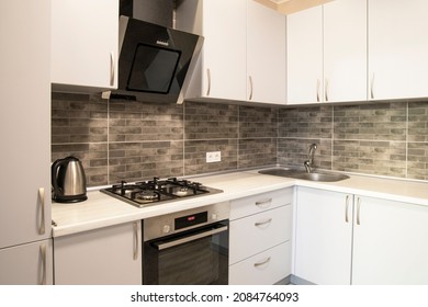 Modern Small Kitchen With Grey Brick Tiles And Grey Cabinets Close Up