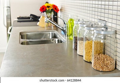 Modern Small Kitchen Interior With Glass Jars On Natural Stone Countertop