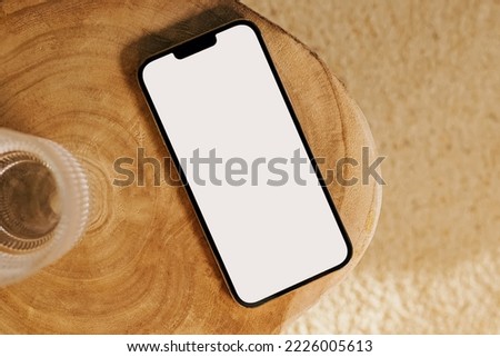 Modern smart phone mock-up, mobile phone with white empty screen on the wooden table, top view