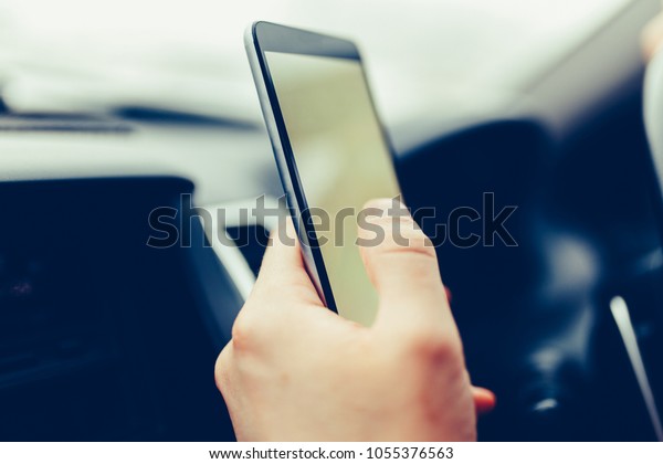 Modern smartphone with blank screen with copy space\
for your text or design, close-up of male driver hands using mobile\
phone in luxury car. Phone touch screen and GPS navigation. Stylish\
toned photo