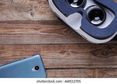 Modern smartphone with empty screen and virtual reality goggles