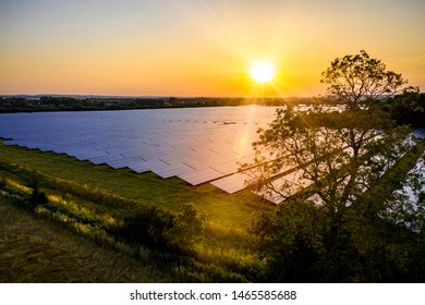 Modern Solar Farm In The Countryside At Sunrise On A Summers Day