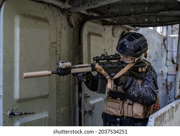 Modern Soldier In Black Multicam Uniform With Rifle, Urban Background 