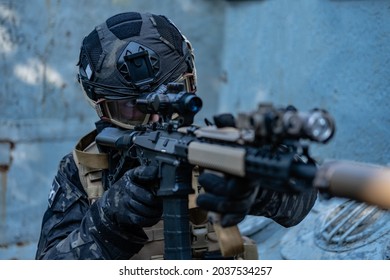 Modern Soldier In Black Multicam Uniform With Rifle, Urban Background 