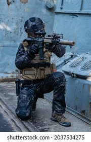 Modern Soldier In Black Multicam Uniform With Rifle, Urban Background 