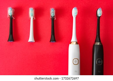Modern sonic or electric toothbrush set with replacement heads on flat lay background. Concept of professional oral care and healthy teeth by using smart sonic toothbrush