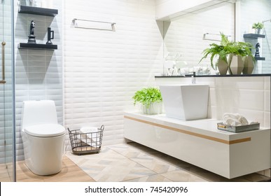 Modern spacious bathroom with bright tiles with toilet and sink. Side view