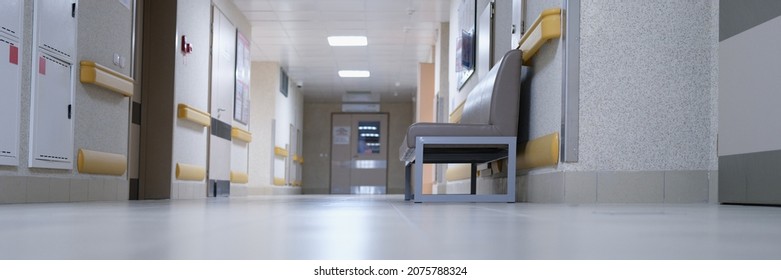 Modern spacious hospital corridor with comfortable couches for patients