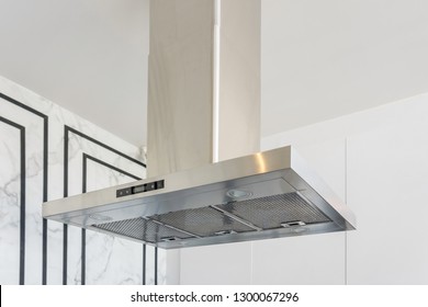 Modern stainless steel And Range hood in the kitchen interior. Stainless Steel Cooker Hood with light on. Kitchen Appliances