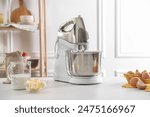 Modern stand mixer and ingredients for dough on white table indoors