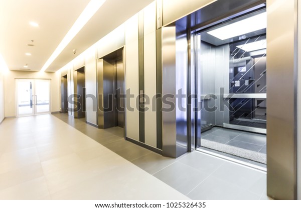Modern steel elevator cabins in a business lobby\
or Hotel, Store, interior, office,perspective wide angle. Three\
elevators in hotel\
lobby.