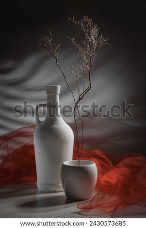 Modern still life with a dry branch in a white vase.