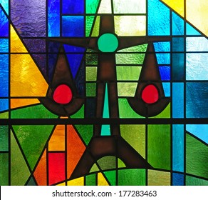 Modern Strained Glass Window Depicting Scales Of Justice Within Colorful Abstract Design As Symbol Of Social Justice