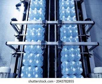 Modern strapping and transporting machine for packaging line at beverage plant.